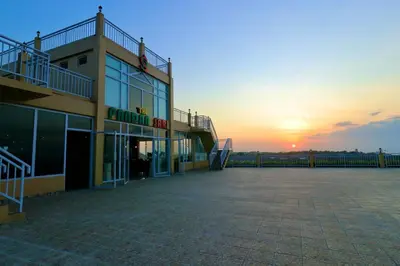 a large building with a sunset in the background at The Pandan Sari Hotel in Jimbaran