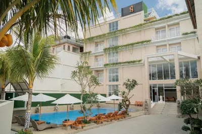 a hotel with a swimming pool in front of a building at The Pandan Sari Hotel in Jimbaran