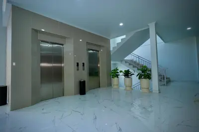 a hallway with three potted plants in a building at The Pandan Sari Hotel in Jimbaran