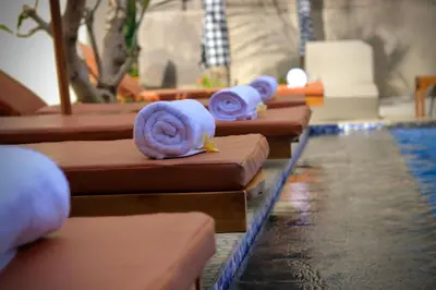 a row of brown tables with towels on them at The Pandan Sari Hotel in Jimbaran