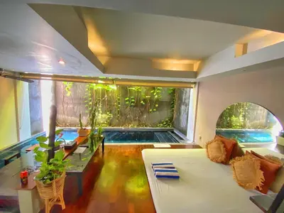 a living room with a large aquarium and a couch at Venus Private Pool Kuta By iLys Collection in Kuta