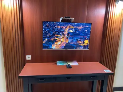 a table in a room with a tv on a wall at The Tandibayang Hotel & Villas in Legian