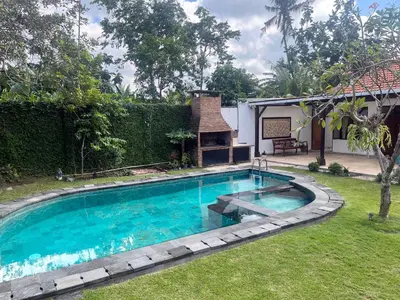 a swimming pool in a yard with a house at Eimas Hive in Kerobokan