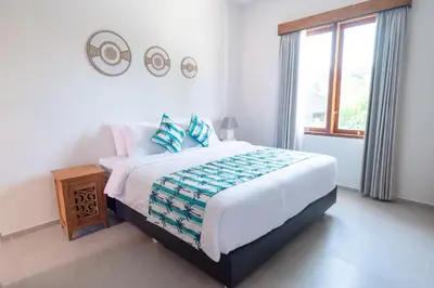 a bedroom with a large bed and a window at Villa Dimaz in Seminyak