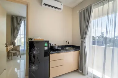 a small kitchen with a sink and a refrigerator at Bustle Base Coliving and Coworking Space in Legian