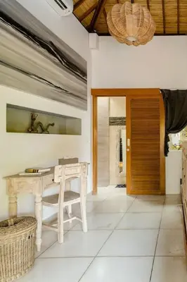 a dining room with a table and a wooden door at 2 Bedroom Villa with Pool Seminyak with Car Park in Seminyak