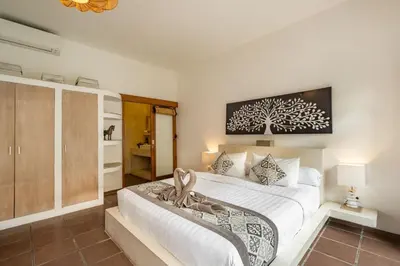 a bedroom with a large bed with a tree picture on the wall at Cozy 2 Bedroom Villa in Seminyak with private Pool in Seminyak