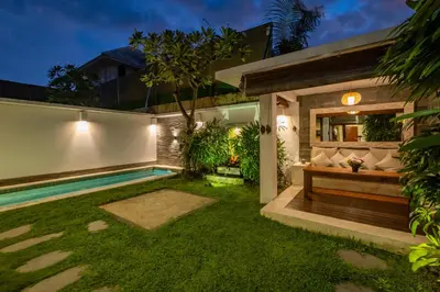 a garden with a bench and a swimming pool at Villa private Pool in Seminyak, Car Park fast WIFI in Kuta