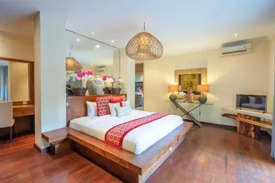 a bedroom with a large bed and a television at 4BR Villa with Large Pool at Seminyak Beach in Seminyak
