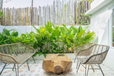 a patio with two chairs and a wooden stump at 4BR Villa with Large Pool at Seminyak Beach in Seminyak