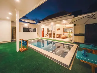 a swimming pool in a house with green grass at Villa Zanetta By Bali Asia Villa in Kerobokan