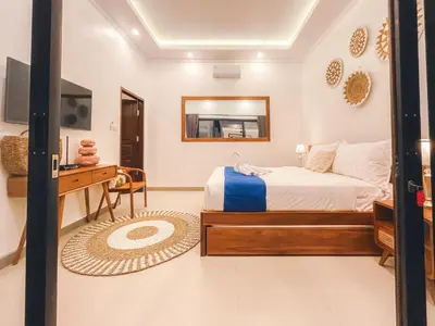 a bedroom with a bed and a table and a mirror at Villa Zanetta By Bali Asia Villa in Kerobokan
