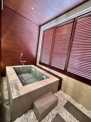 a bathroom with a large tub with a window at Putu Soemantri Four Persons Villas in Denpasar