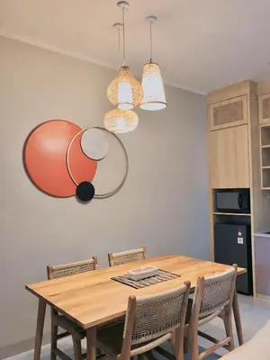 a dining room table with chairs and pendant lights at Putu Soemantri Four Persons Villas in Denpasar
