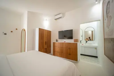a bedroom with a bed and a sink and a mirror at Casa Solace - New! Sparkling villa in the heart of Berawa or Canggu in Canggu