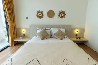 a bedroom with a large white bed with pillows at Chic modern villa, 5 minute walk to Legian beach in Legian