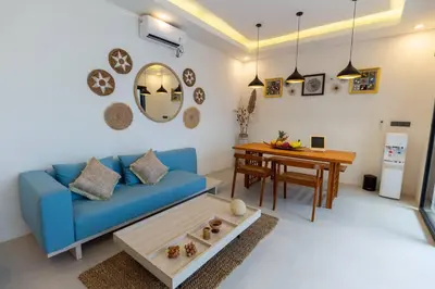 a living room with a blue couch and a table at Chic modern villa, 5 minute walk to Legian beach in Legian