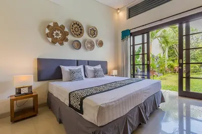 a bedroom with a large bed and a large window at Luxury Hideaway 4 Br Villa 5 minutes to the beach in Seminyak
