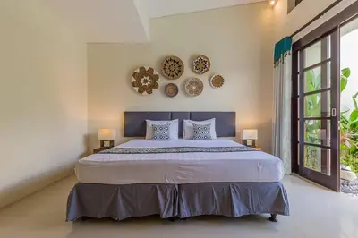 a bedroom with a large bed and two plates on the wall at Luxury Hideaway 4 Br Villa 5 minutes to the beach in Seminyak