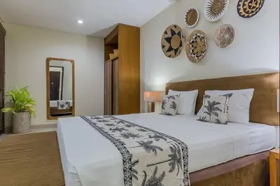 a bedroom with a large bed and a mirror at Luxury Hideaway 4 Br Villa 5 minutes to the beach in Seminyak