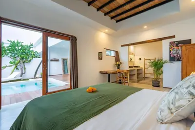 a bedroom with a large bed and a swimming pool at Villa Wamwui by DreamAwayBali in Seminyak