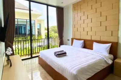 a bedroom with a bed and a balcony at Cakrawala 3 Bedroom Villa in Jimbaran