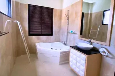 a bathroom with a tub and a sink and a bath tub at Cakrawala 3 Bedroom Villa in Jimbaran