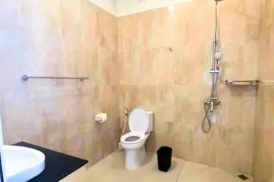 a bathroom with a toilet and a sink and a shower at Cakrawala 3 Bedroom Villa in Jimbaran