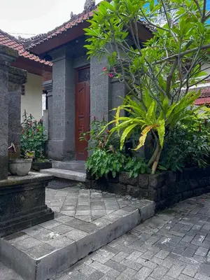 a house with a red door and some plants at Kaman Bali Guesthouse in Seminyak