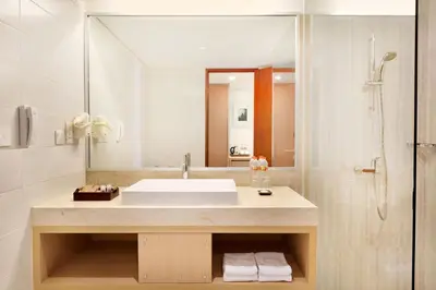 a bathroom with a sink and a shower at Ramada Encore by Wyndham Seminyak Bali in Seminyak