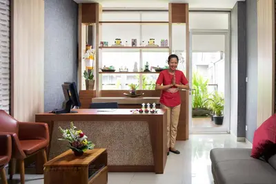 a woman standing in a room with a game of chess at Ramada Encore by Wyndham Seminyak Bali in Seminyak