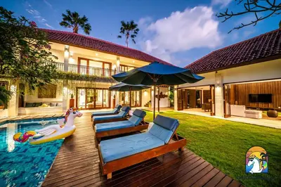 a backyard with a pool with a pool noodle inflatables and a house at Villa Kajou - by Unicorn Villas Bali in Seminyak
