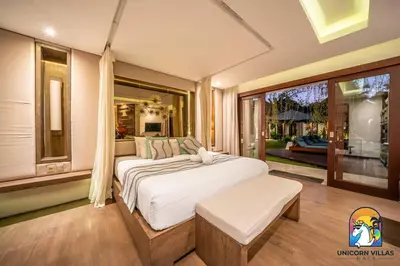 a bedroom with a large bed and a large window at Villa Kajou - by Unicorn Villas Bali in Seminyak