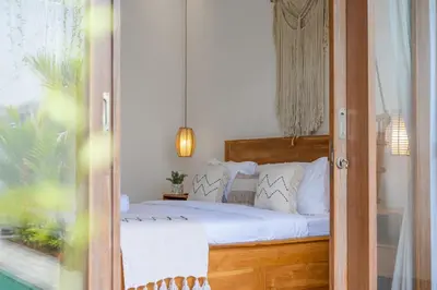 a bedroom with a bed with white pillows at Ami villa in the heart of Canggu in Canggu
