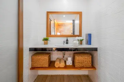 a bathroom with a sink and a mirror and baskets at Ami villa in the heart of Canggu in Canggu