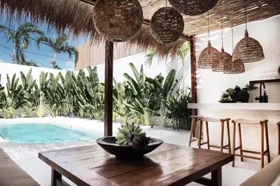 a dining room with a table and a swimming pool at Villa Almaz Seminyak in Seminyak