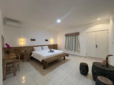 a bedroom with a bed and a desk in it at Lavender star house in Kuta