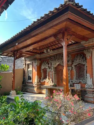 a wooden pavilion in a garden with flowers at Pondok Ledog 02 in Jimbaran