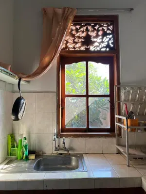 a kitchen with a sink and a window at Pondok Ledog 02 in Jimbaran