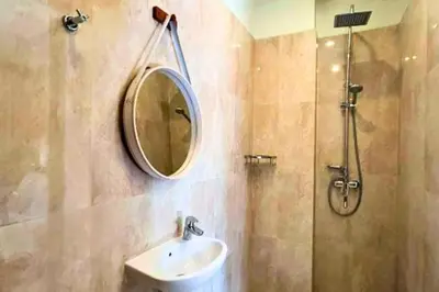 a bathroom with a sink and a mirror and a shower at Lariska 1 BR Superior Queen Room in Jimbaran