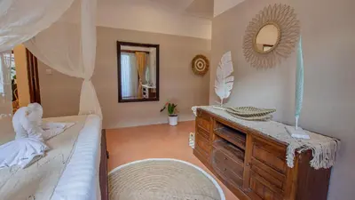 a bedroom with a bed with a dresser and a mirror at Leluhur 2 - 3BR, Free Nmax, Airport Pick Up and YT Premium in Seminyak