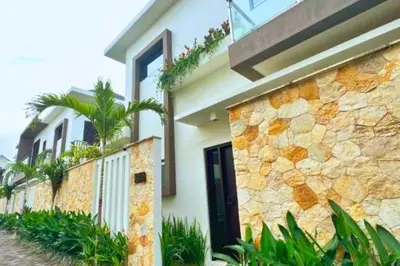 a house with a stone wall and a door at Reline 1 BR Studio with Sofa Bed in Jimbaran