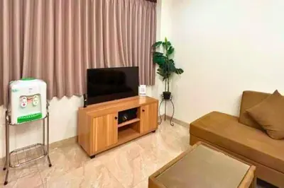 a living room with a television on a wooden cabinet at Reline 1 BR Studio with Sofa Bed in Jimbaran