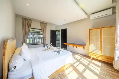 a bedroom with a white bed with two stuffed animals on it at Aradhia Villa Nusa Dua in Nusa Dua