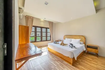 a bedroom with a large bed and a window at Aradhia Villa Nusa Dua in Nusa Dua