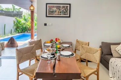 a dining room with a table and chairs and a couch at Villa Thyme, secluded 2 bedroom pool Villa, 2 minutes walking to cafe in Canggu