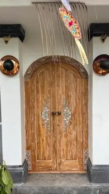 a wooden door in a building with a decoration at Villa Thyme, secluded 2 bedroom pool Villa, 2 minutes walking to cafe in Canggu