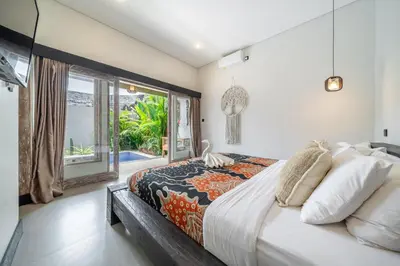 a bedroom with a large bed and a large window at Villa Thyme, secluded 2 bedroom pool Villa, 2 minutes walking to cafe in Canggu