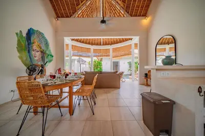 a dining room and living room with a table and chairs at Villa Antea in Seminyak