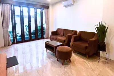 a living room with two couches and a table at Willy 4 BR Comfort Quadruple Room in Jimbaran